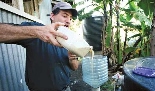 トーマス・カルヘインが細かく刻んだ食べ物の残り物をタンクに注ぐ