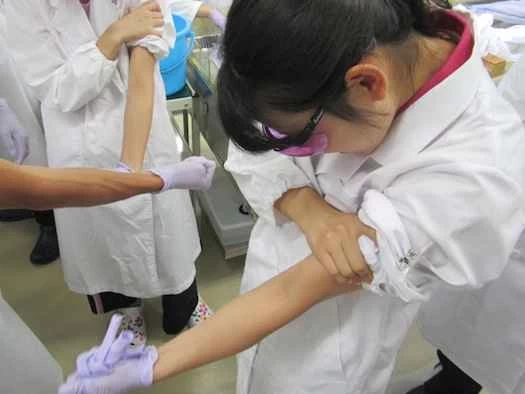 解剖学の授業で生徒たちがメガネの実験をしている