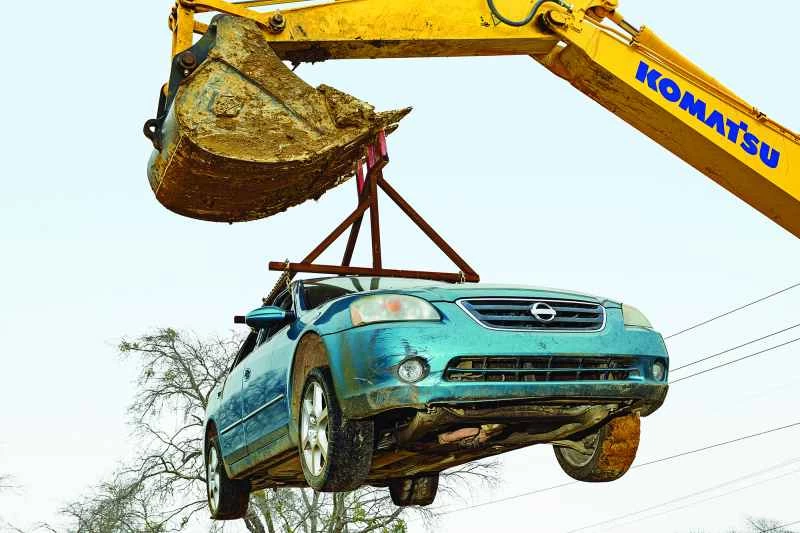 車を持ち上げる掘削機