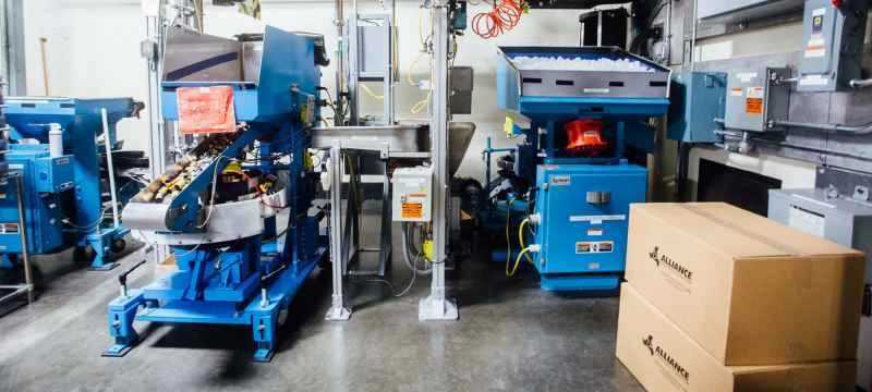 空のフィルム缶を漏斗で送る機械